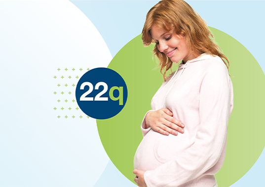 pregnant woman cradles her stomach highlighting the importance of screening for 22q